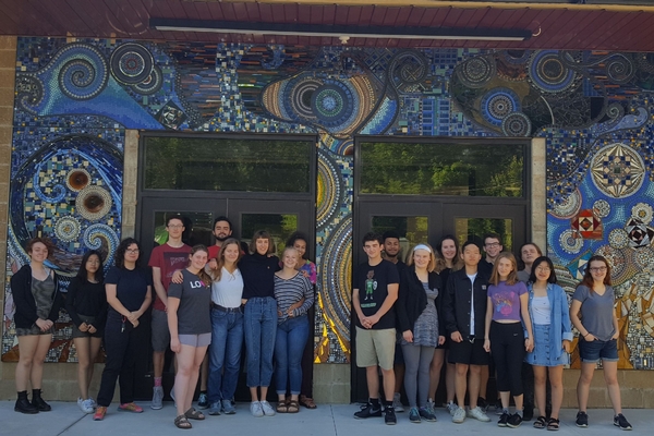 High school seniors in front of mosaic outside building entrance