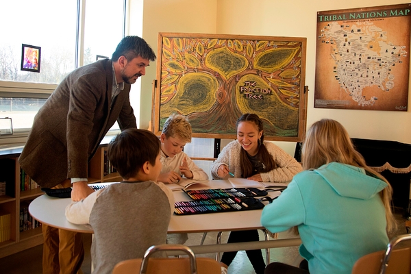 Grades teacher talking with three students