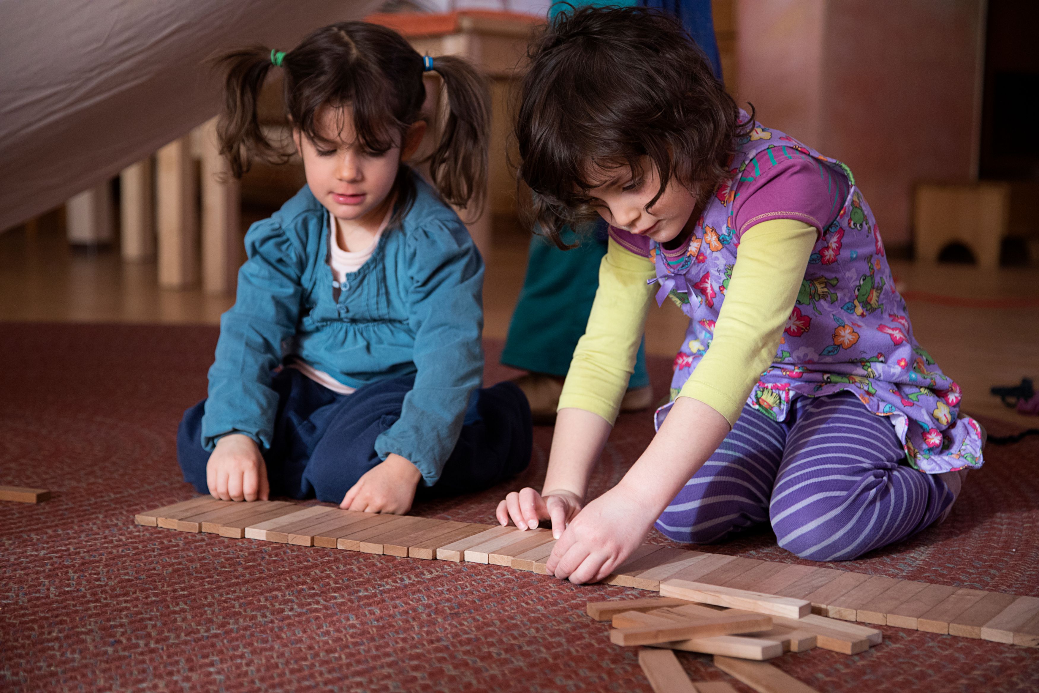 Two girls playing with wooden blocks