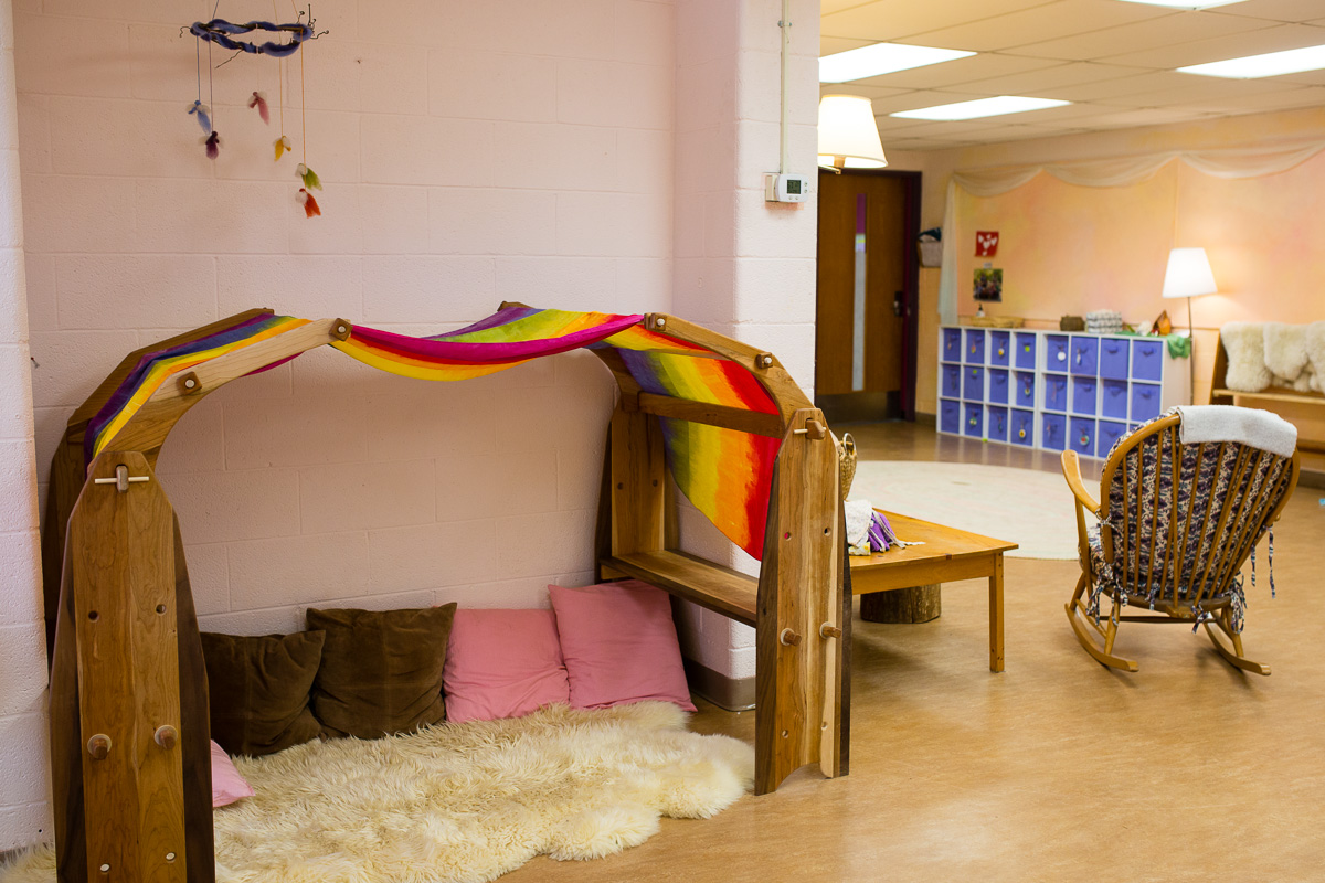 Indoor play area with silk-scarf-covered wooden toys