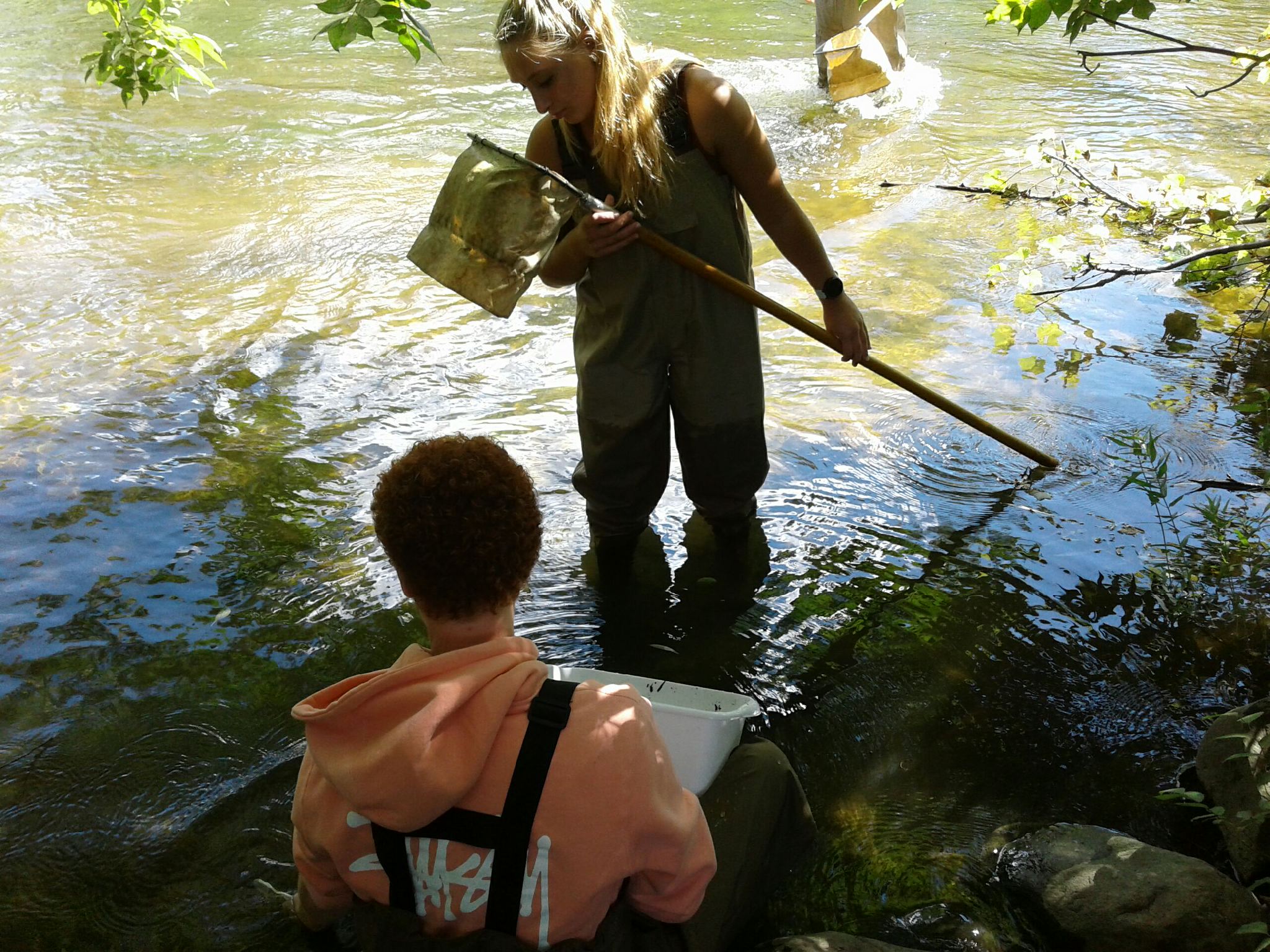 Girl and boy in river with net