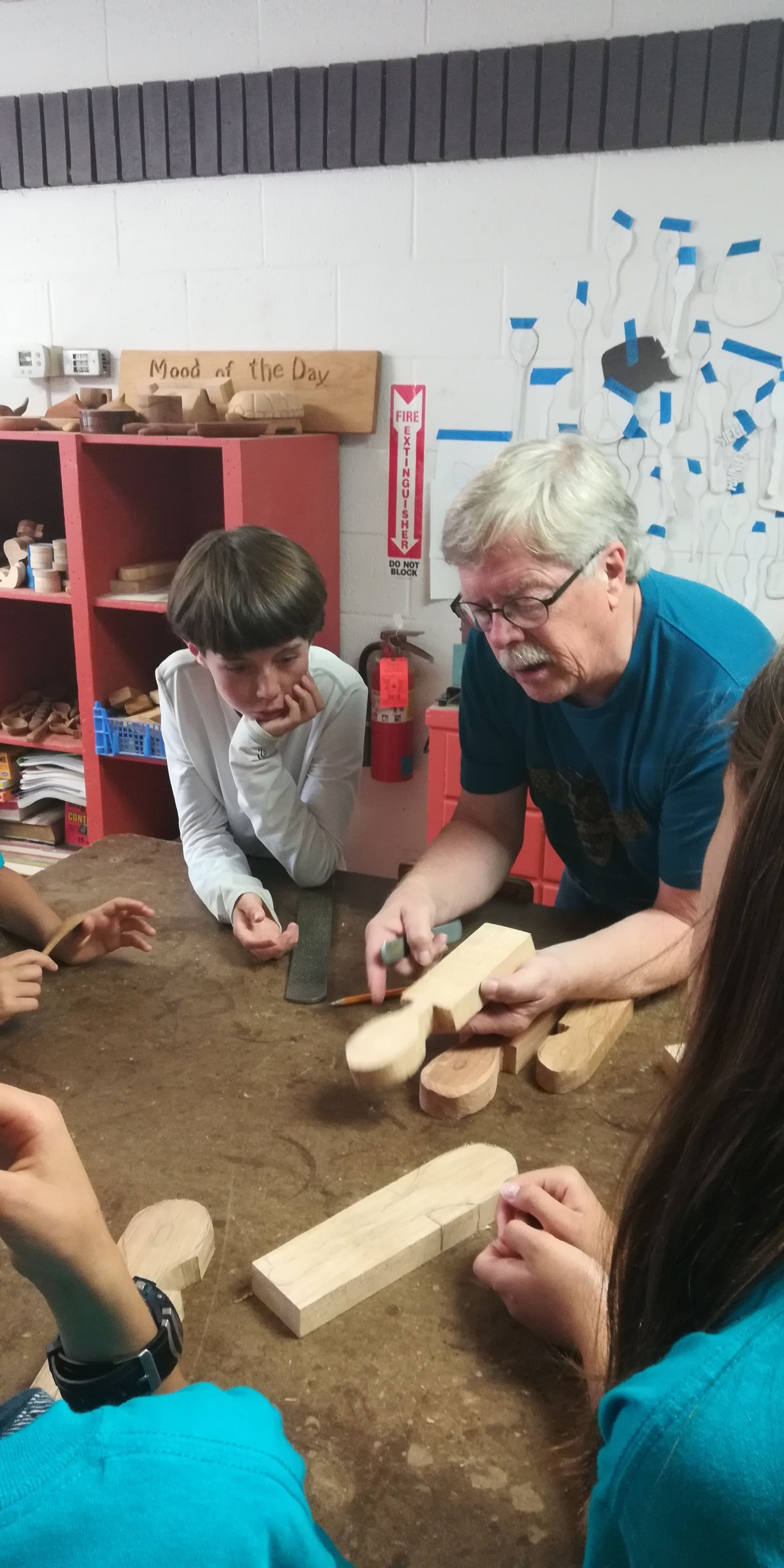 Teacher and student carving wood