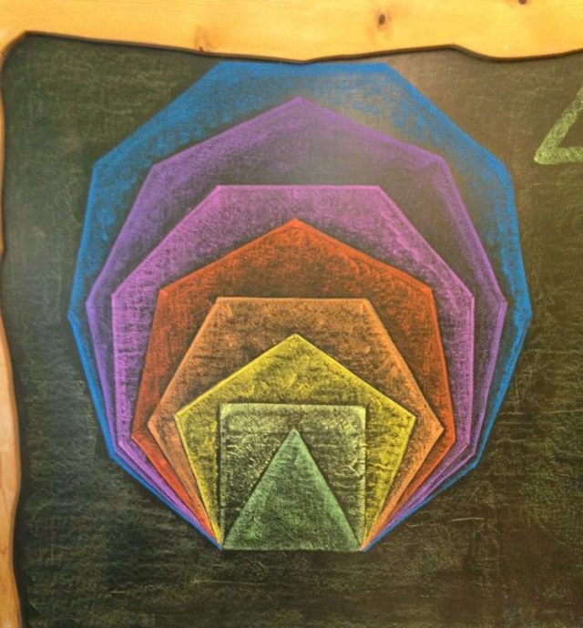 Concentric pentagons on chalkboard 